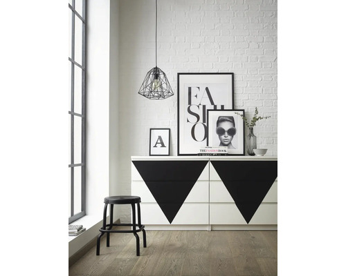 Helles Zimmer mit Kommode, Dekorationen, Lampe und Hocker