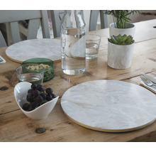 Décoration de table avec assiettes, verres, carafe d''eau, bol de raisins et plantes sur une table en bois