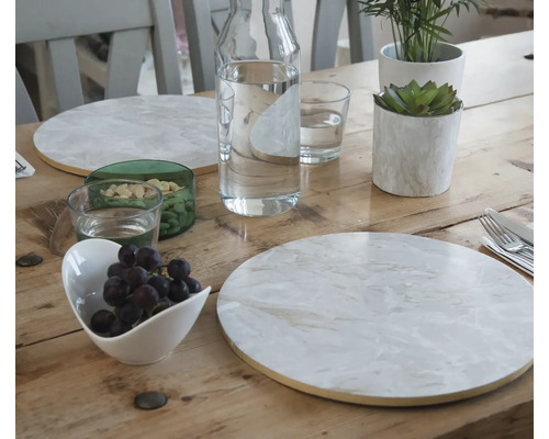 Table en bois dressée avec assiettes, boissons, fruits et décoration