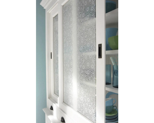 Gros plan d''un buffet de cuisine blanc avec des portes en verre à motifs floraux.