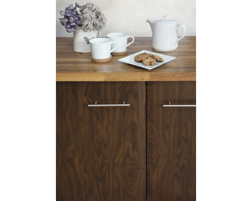 Scène de cuisine avec vaisselle, pâtisseries et décoration florale sur un plan de travail au-dessus d''un placard