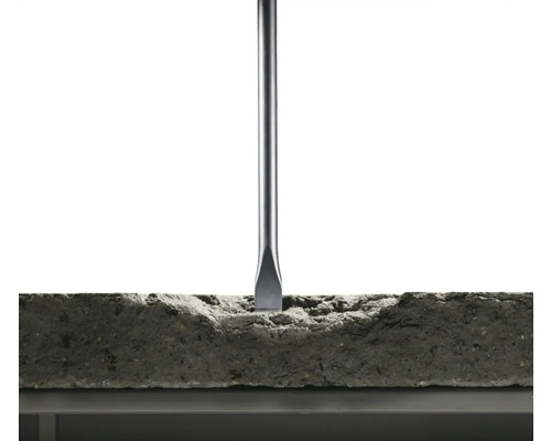 Un burin travaille un bloc de pierre.