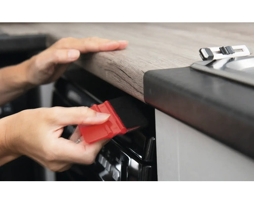 Personne lisse le film avec une raclette sur un appareil de cuisine