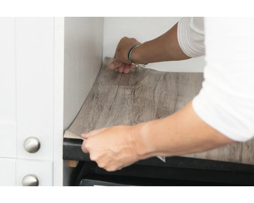 Personne appliquant une feuille de bois dans une cuisine