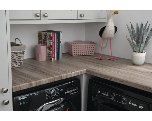 Buanderie avec machine à laver, sèche-linge et plan de travail aspect bois