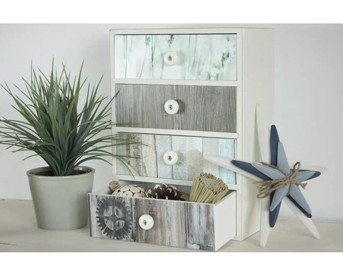 Commode décorative avec quatre tiroirs, plante artificielle en pot et étoile décorative