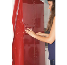 Une femme applique un film décoratif sur une armoire