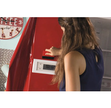 Femme appliquant un film avec une raclette sur un réfrigérateur