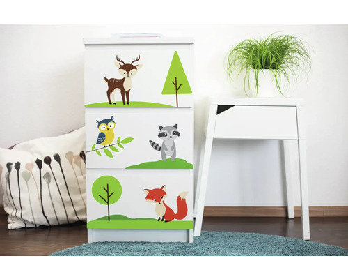 Kommode mit Waldtier Motiven im Kinderzimmer neben einem Beistelltisch und Kissen