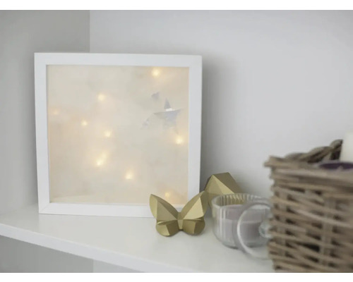 Dekoratives Lichtobjekt mit Sternen und Lichterkette im weißen Rahmen