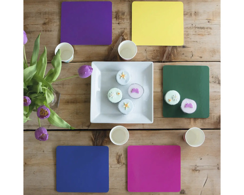 Dekorierter Tisch mit Blumen, Papierbechern, Untersetzern und Cupcakes
