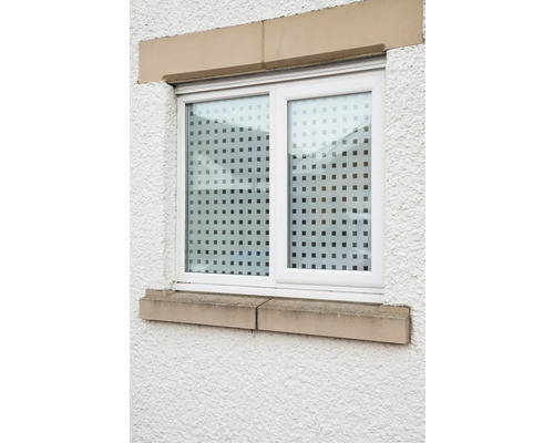 Fenêtre avec film à motifs à pois sur un mur texturé