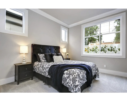 Chambre avec lit, tables de chevet et fenêtre avec film décoratif