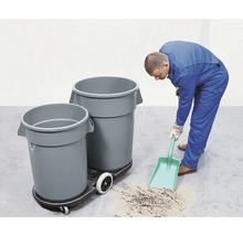 Un homme nettoie le sol avec une pelle à poussière à côté de poubelles sur une planche à roulettes