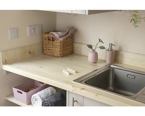 Une buanderie avec un plan de travail, un évier, un panier à linge et une boîte de rangement