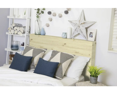 Chambre à coucher avec tête de lit en bois, coussins et éléments décoratifs pour une atmosphère chaleureuse