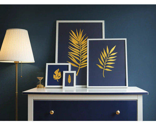 Images décoratives avec motifs de feuilles sur une commode avec lampe