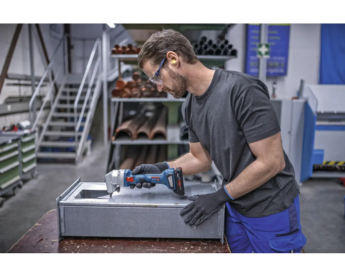 Artisan coupant du métal avec une grignoteuse sans fil