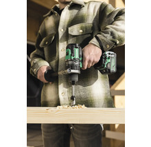 Handwerker bohrt mit einem Akku-Bohrschrauber ein Loch in ein Holzbrett.