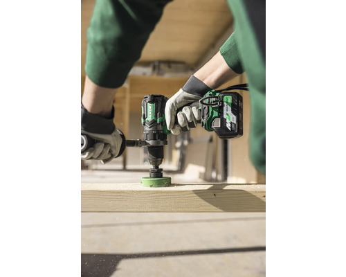 Eine Person bohrt mit einem Akku-Bohrschrauber ein Loch in ein Holzbrett