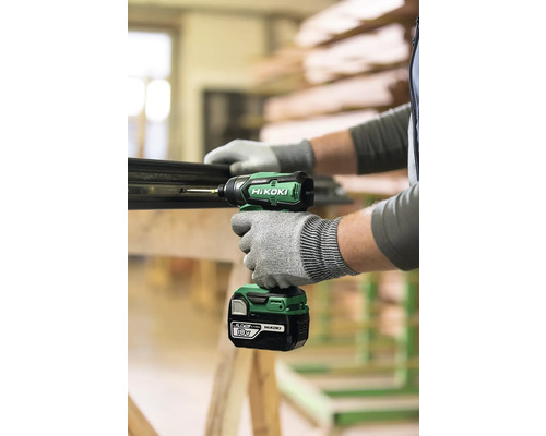 Un homme visse une vis dans une pièce à l''aide d''une visseuse à percussion sans fil