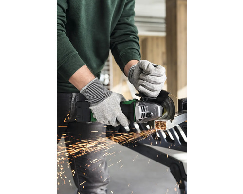 Eine Person benutzt einen Winkelschleifer mit Schutzhandschuhen, um ein Metallstück zu schneiden, wobei Funken sprühen.