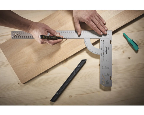 Eine Person markiert ein Holzbrett mit einer Markierung und einem Winkel.