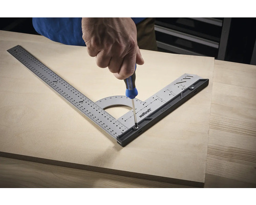 Handwerker schraubt mit Schraubendreher Multifunktionswinkel auf Holzbrett