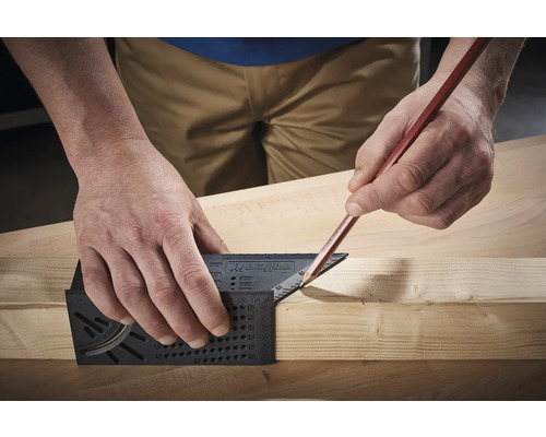 Handwerker benutzt Zimmermannswinkel und Bleistift zum Anzeichnen auf Holz