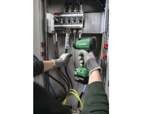 Elektriker arbeitet mit einem Akku-Drehmomentschlüssel an einem Verteilerkasten.