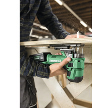 Une personne utilise une scie sauteuse sans fil Hikoki pour scier une planche de bois.