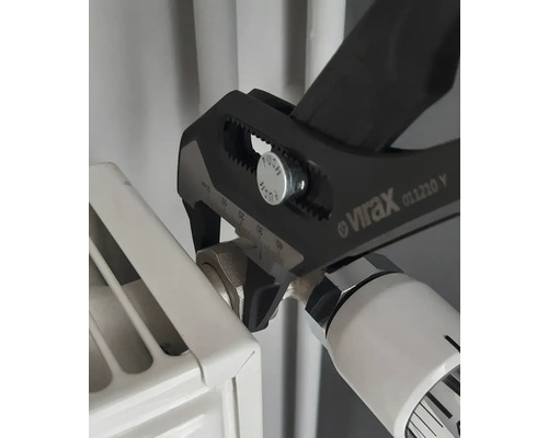Une pince multiprise est utilisée sur une vanne de radiateur.