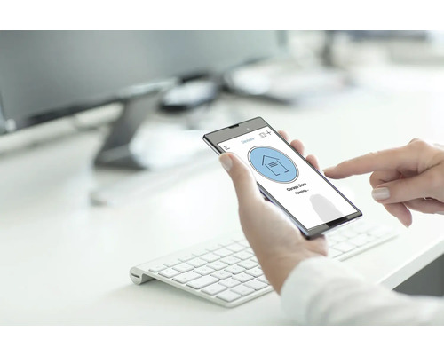 Eine Person bedient ein Smartphone zur Steuerung eines Garagentors