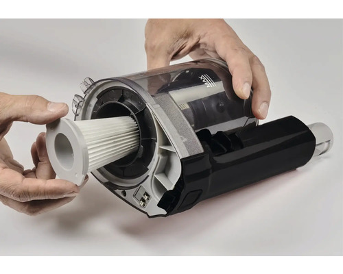 Ein Mann setzt einen Filter in einen Staubsauger.