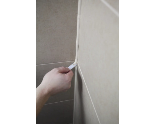 Eine Person glättet eine Fuge mit einem Werkzeug.