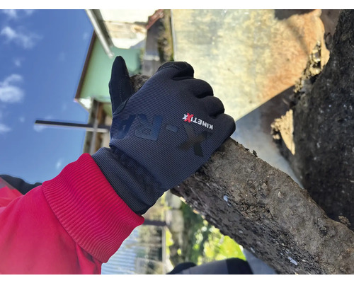 Eine Hand mit Arbeitshandschuh hält einen Stein.