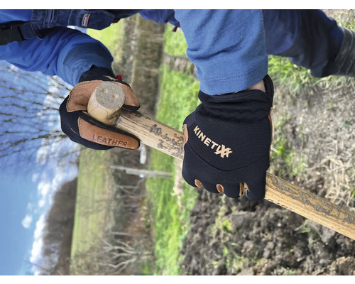 Des mains avec des gants de travail tiennent un marteau