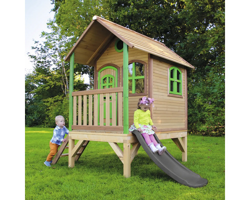 Maisonnette en bois avec toboggan et deux enfants dans le jardin.