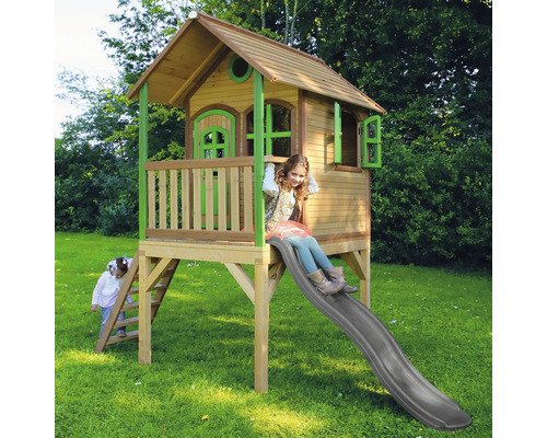 Cabane de jeu en bois avec toboggan et deux enfants jouant dans le jardin.