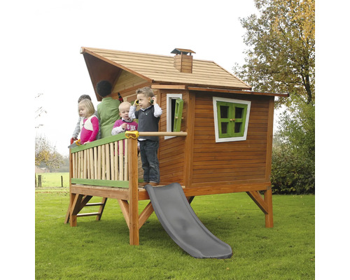 Cabane de jeu en bois avec toboggan et plusieurs enfants dans le jardin.