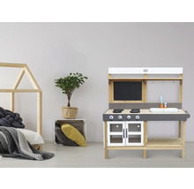 Kinderspielküche aus Holz mit Zubehör und Spielbett im Hintergrund