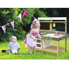 Szene mit Kind an einer Spielküche im Freien mit Tafel, Spüle und Zubehör
