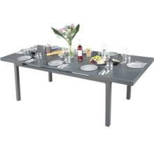 Table de jardin extensible dressée avec vaisselle et décoration.