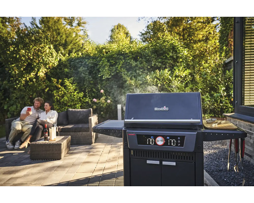 Scène avec barbecue, couple et mobilier de jardin sur une terrasse.
