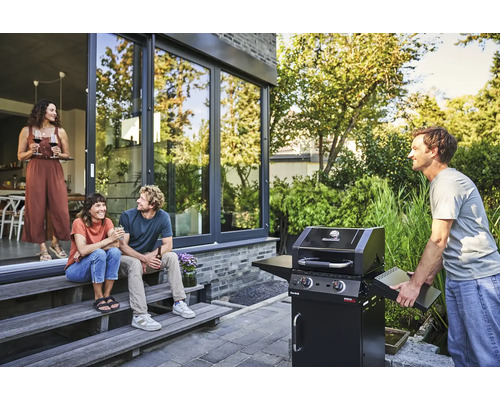 Des personnes font des grillades à l''extérieur sur une terrasse avec un barbecue à gaz Char-Broil.