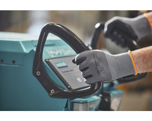 Une personne utilise une machine de nettoyage avec des gants de protection.