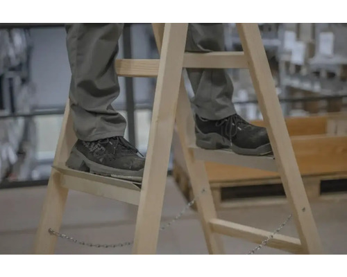 Personne sur échelle en bois avec chaussures de sécurité