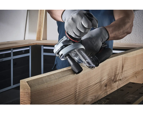 Un homme travaille le bois avec un outil électrique