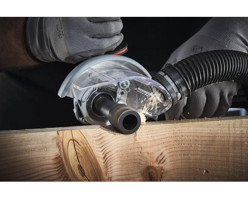 Défonceuse à rainurer en action sur une planche en bois avec projection de copeaux