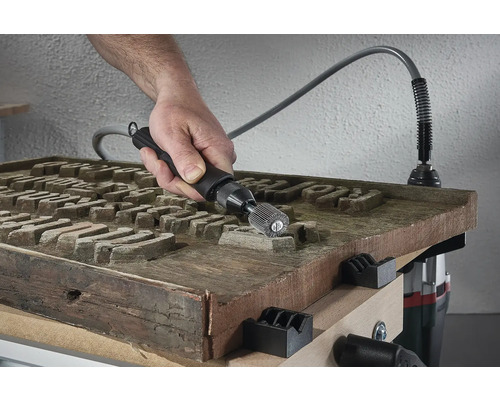 Hand, die eine Holzoberfläche mit einem Schleifwerkzeug bearbeitet